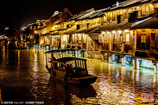 浙江省桐鄉市烏鎮西柵景區火樹銀花不夜天,游客游覽購物、摩肩接踵,感受水鄉古鎮的夜晚風情。(圖片作者:王子瑞)