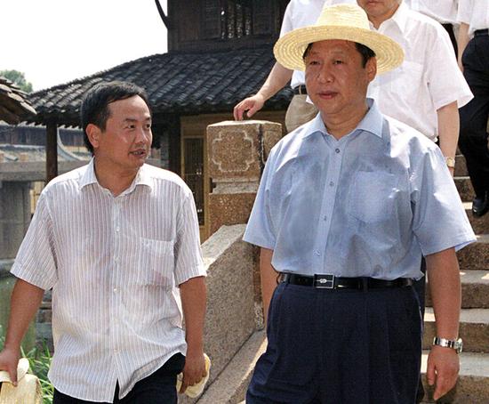 2005年8月3日,時任中共浙江省委書記、省人大常委會主任習近平到烏鎮調研,時任烏鎮古鎮保護與旅游開發管委會主任陳向宏匯報古鎮情況。圖/徐建榮 攝